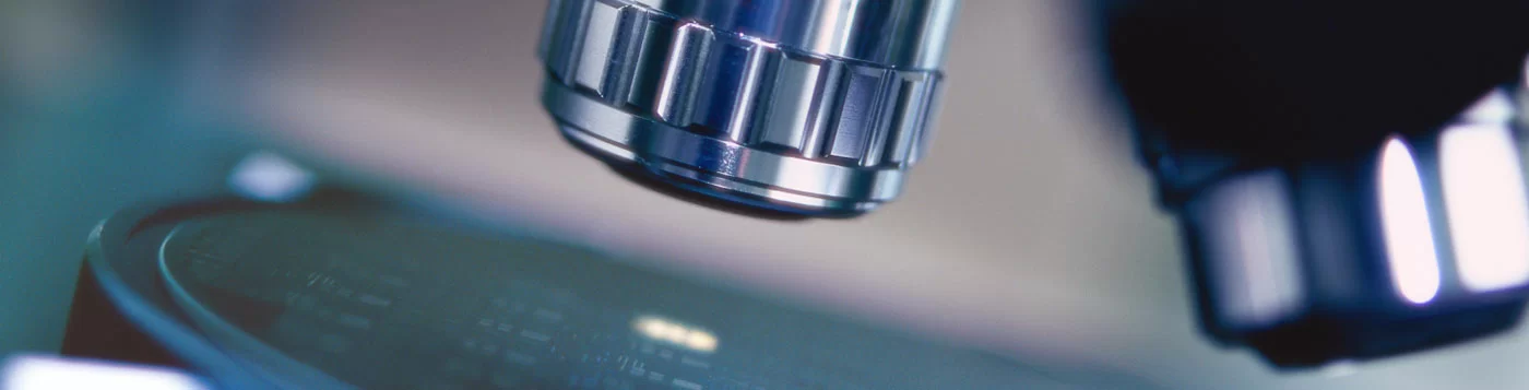 Close-up view of a microscope lens focusing on a sample.