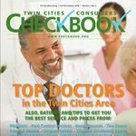 A smiling male doctor with a stethoscope around his neck on the cover of twin cities checkbook magazine, featuring an article about top doctors in the twin cities area.