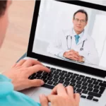 Man attending a virtual medical consultation with a doctor through his laptop.