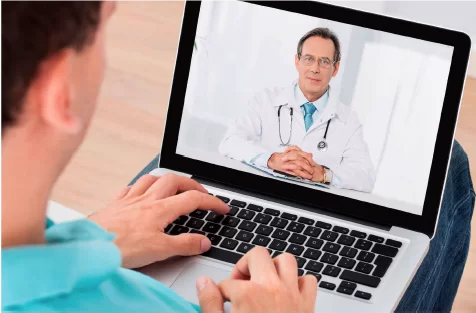 Man attending a virtual medical consultation with a doctor through his laptop.